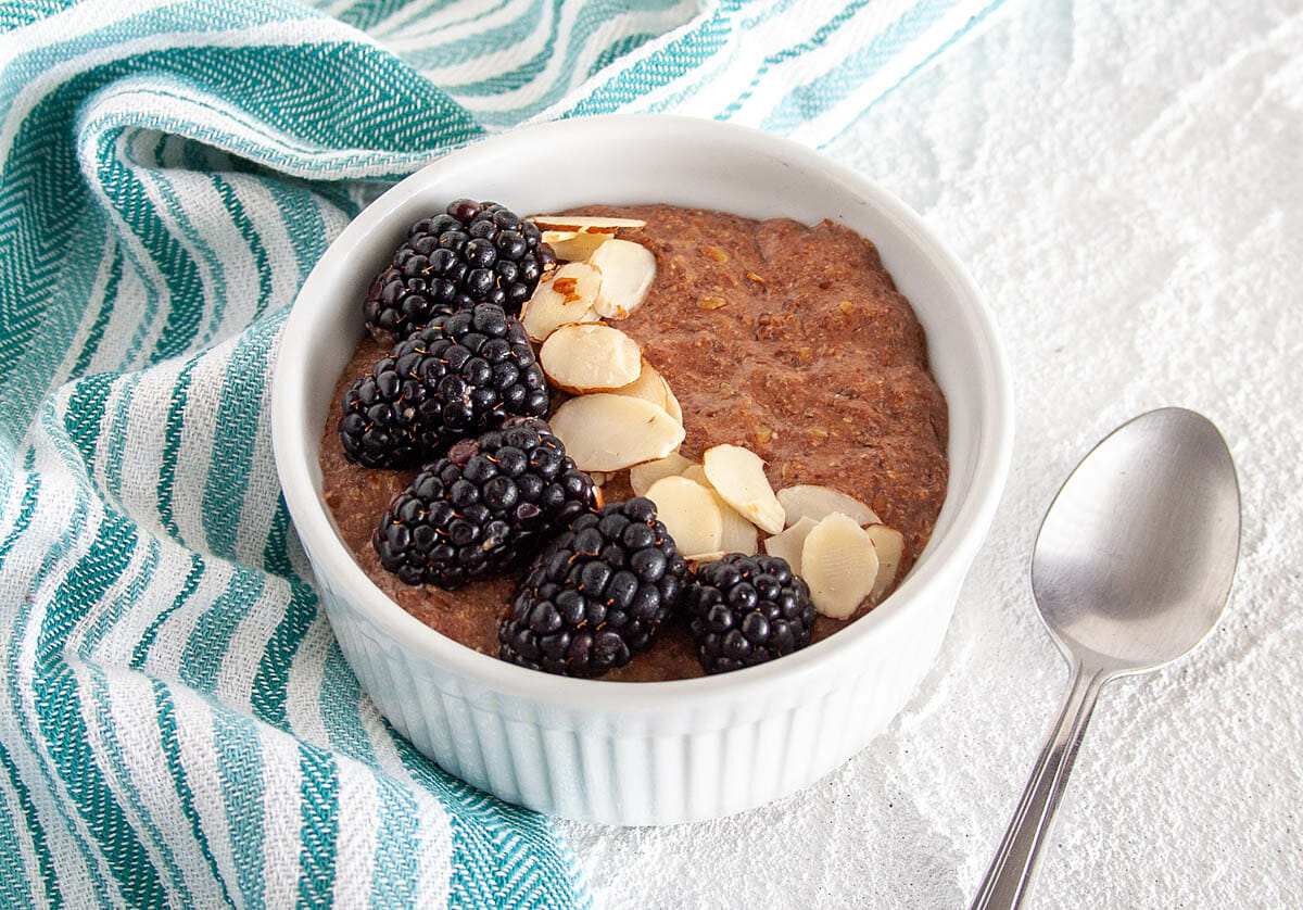 Chocolate Flaxseed Porridge in ramekin with spoon.