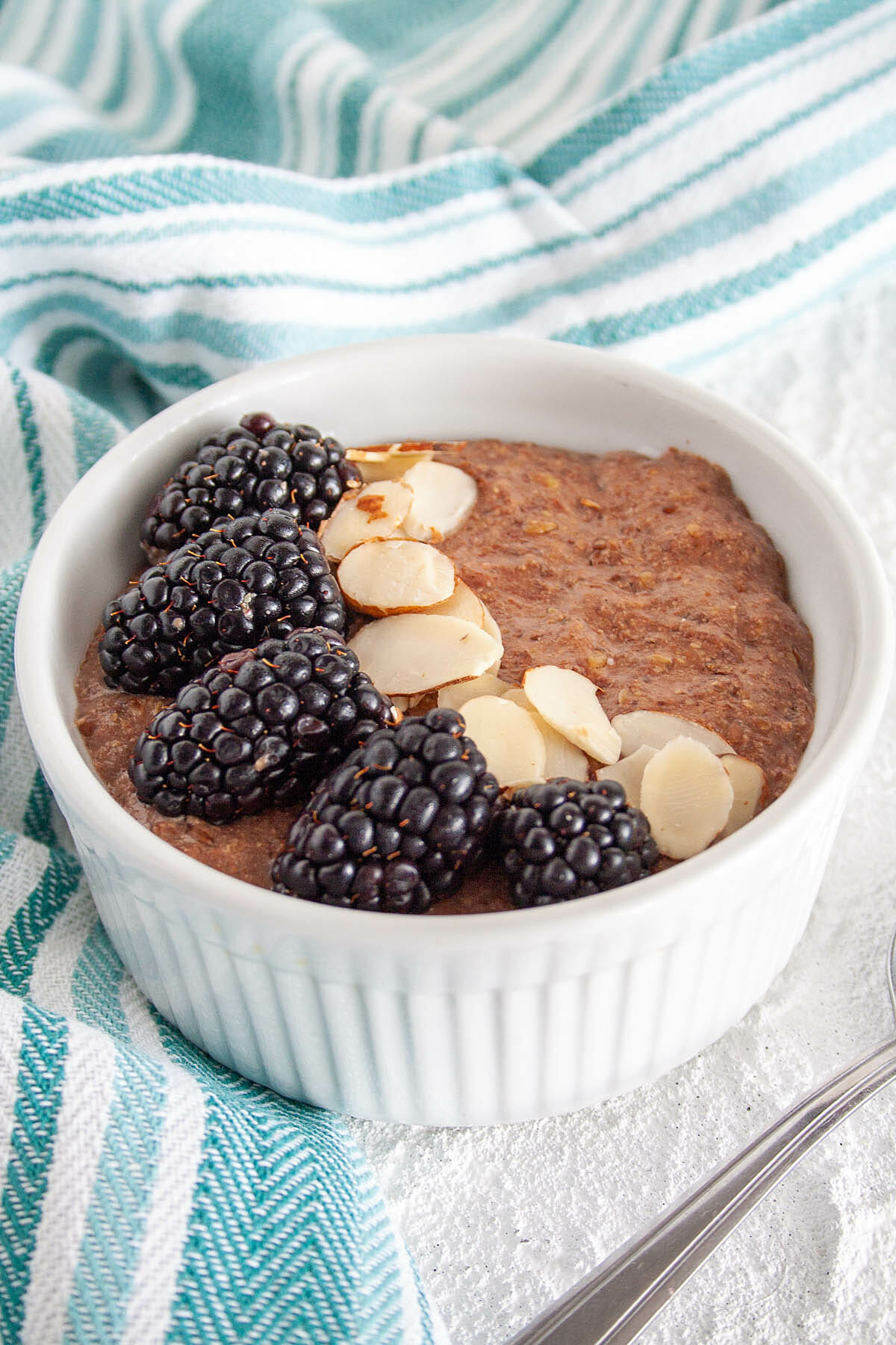 Chocolate Flaxseed Porridge with blackberries and sliced almonds in a ramekin.