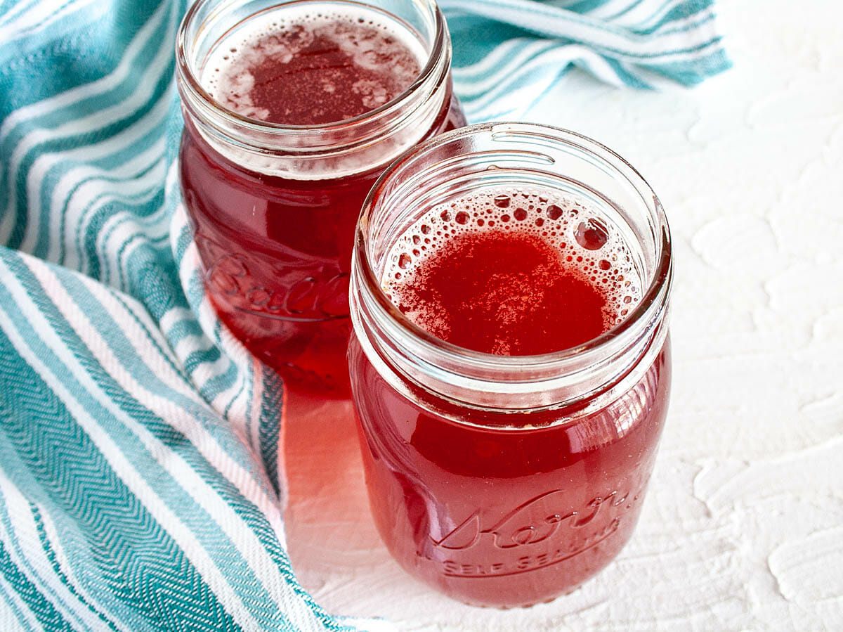 Close up of Pomegranate Kombucha in mason jars.