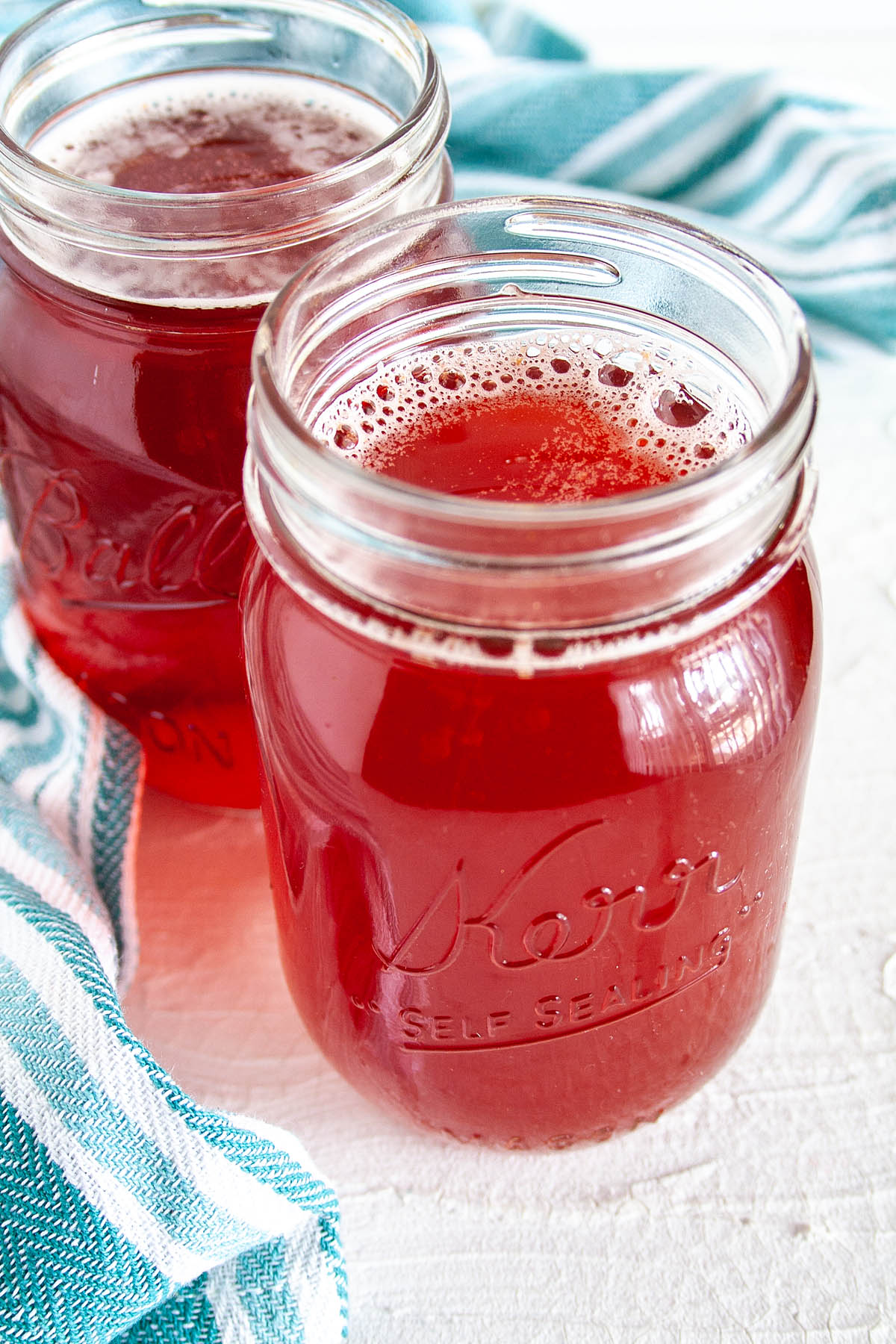 Pomegranate Kombucha in two mason jars.