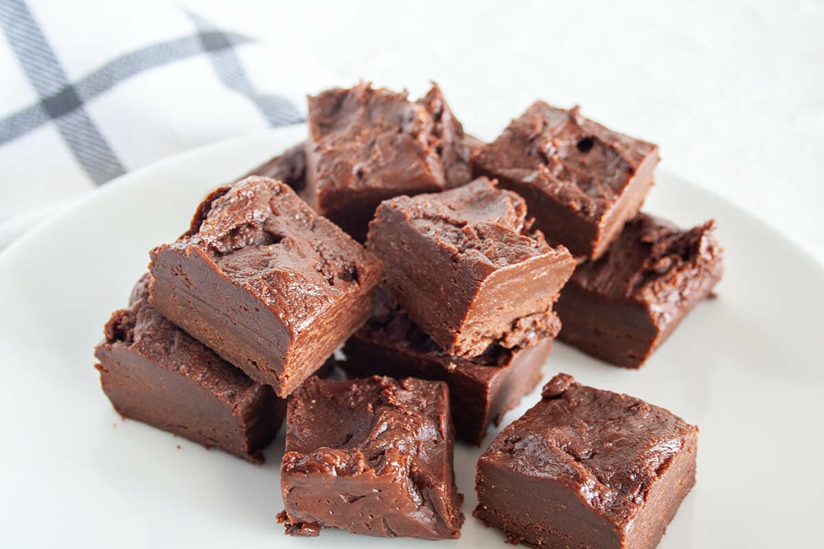 Pieces of fudge stacked on a plate.