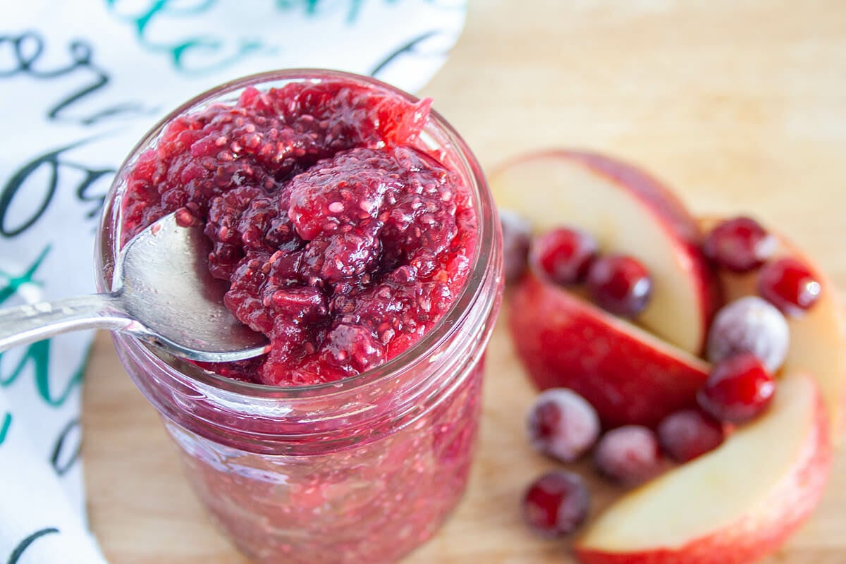 Cranberry Apple Chia Jam in mason jar with spoon.