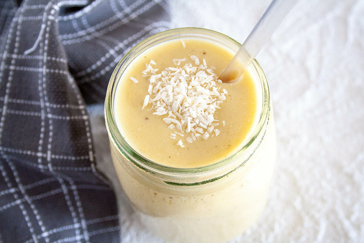 Tropical Smoothie in mason jar with straw.