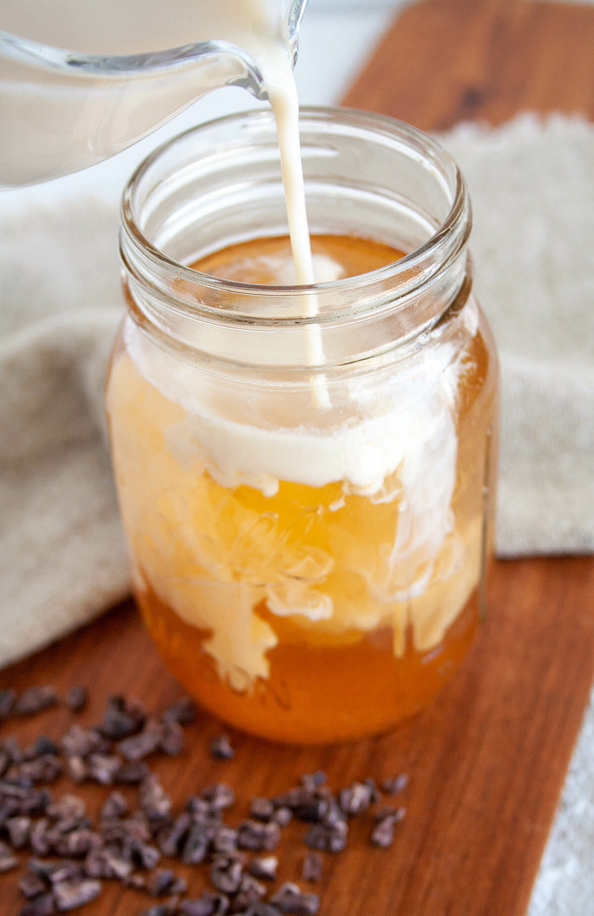 Cold Brew Cacao with almond milk being poured in.