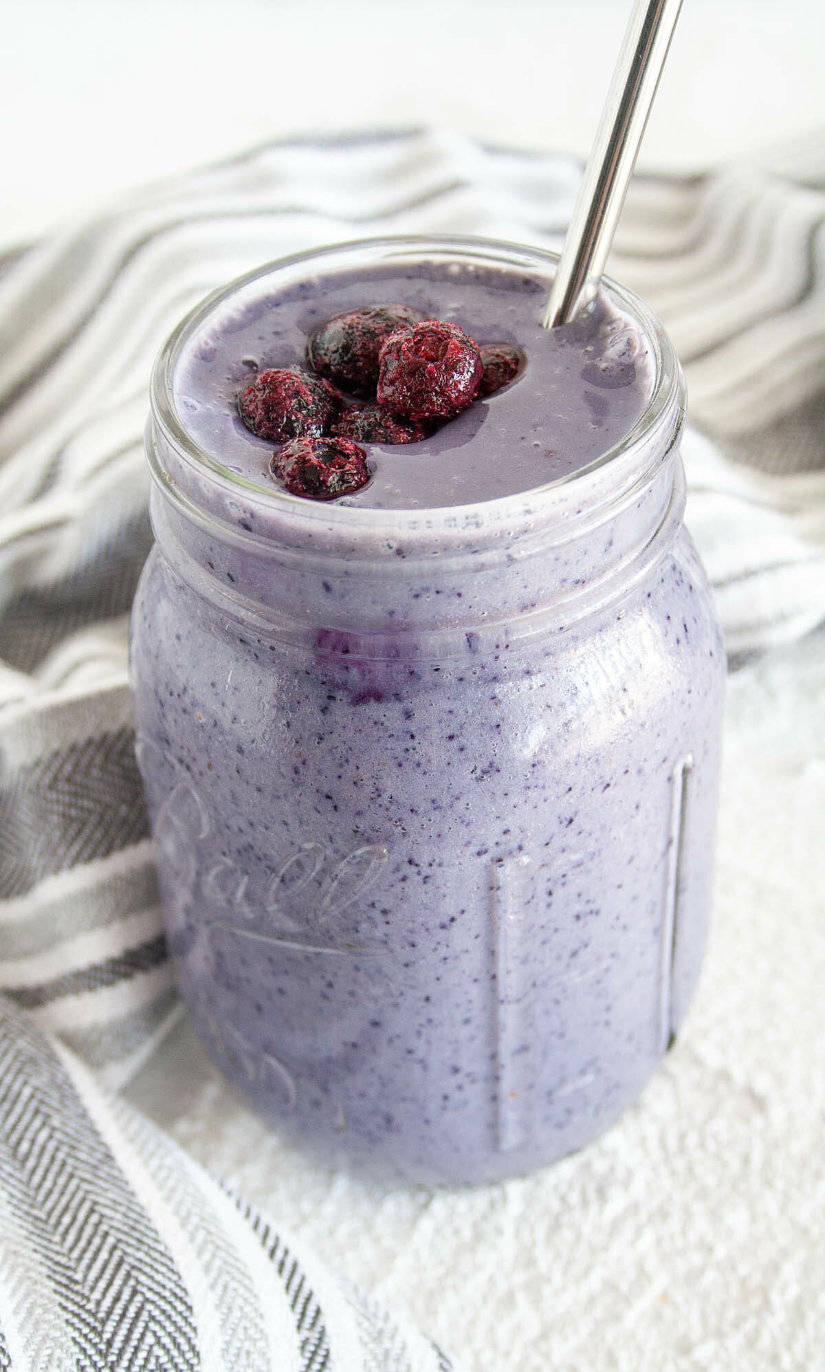 Elderberry Smoothie with blueberries a straw.
