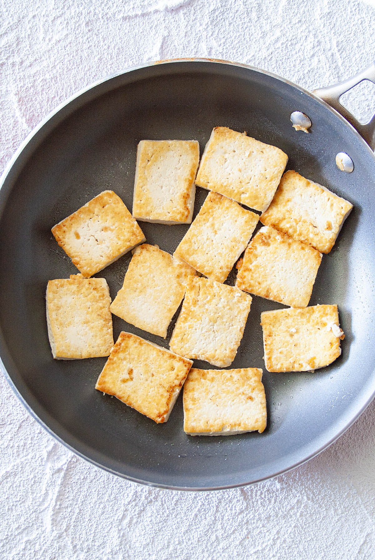 Tofu in frying pan.