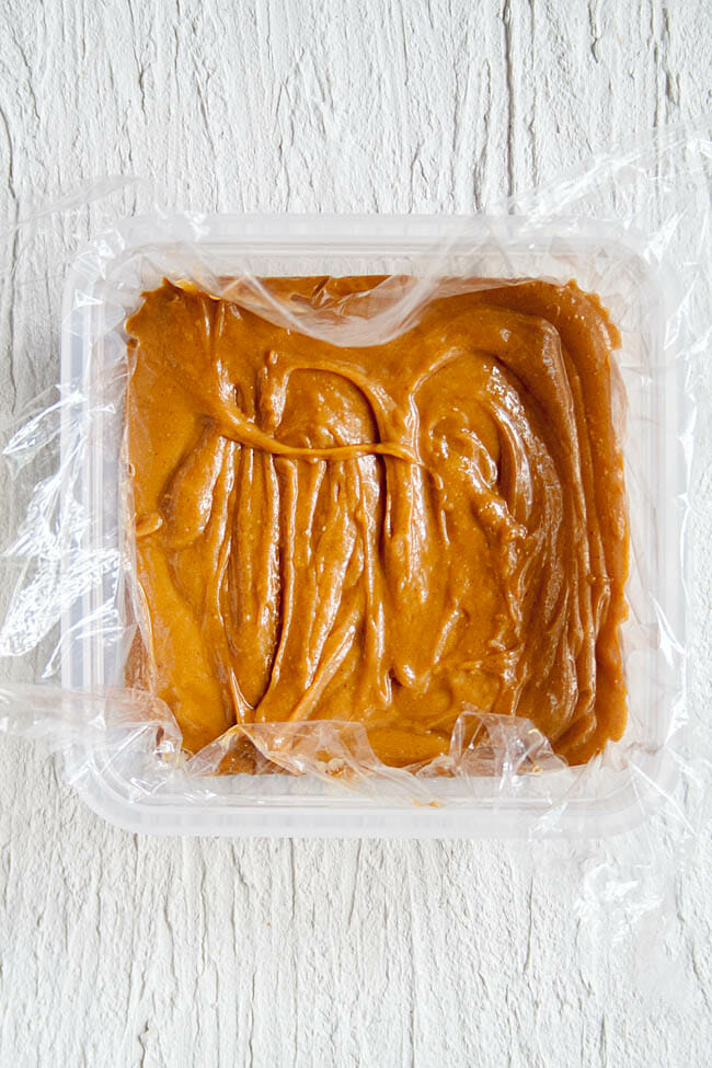 Peanut butter mixture in a plastic wrap lined container before freezing