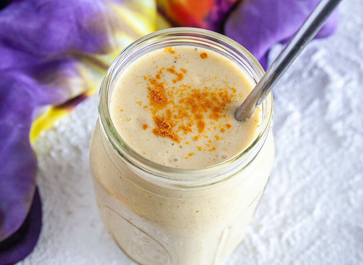 Turmeric Smoothie in a mason jar with metal straw.