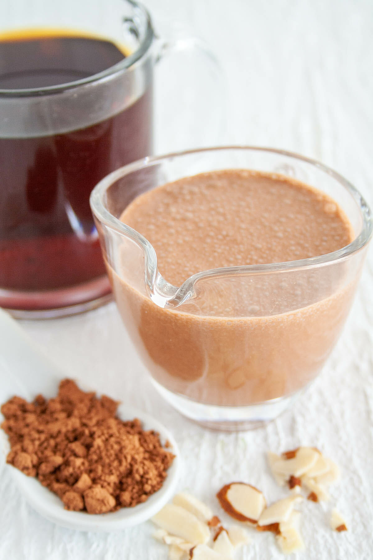 Chocolate Almond Creamer  in a pitcher with a cup of coffee.