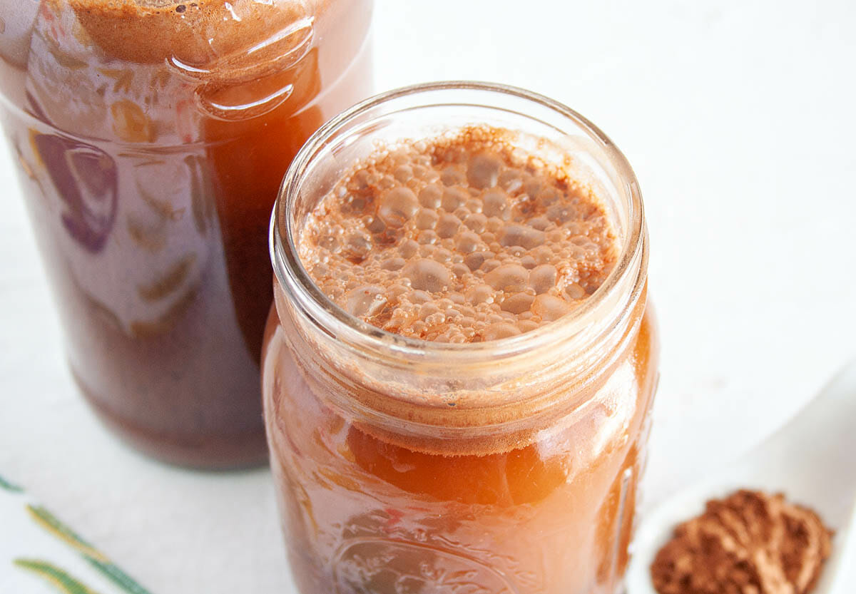 Chocolate Kombucha in mason jar and bottle close up.