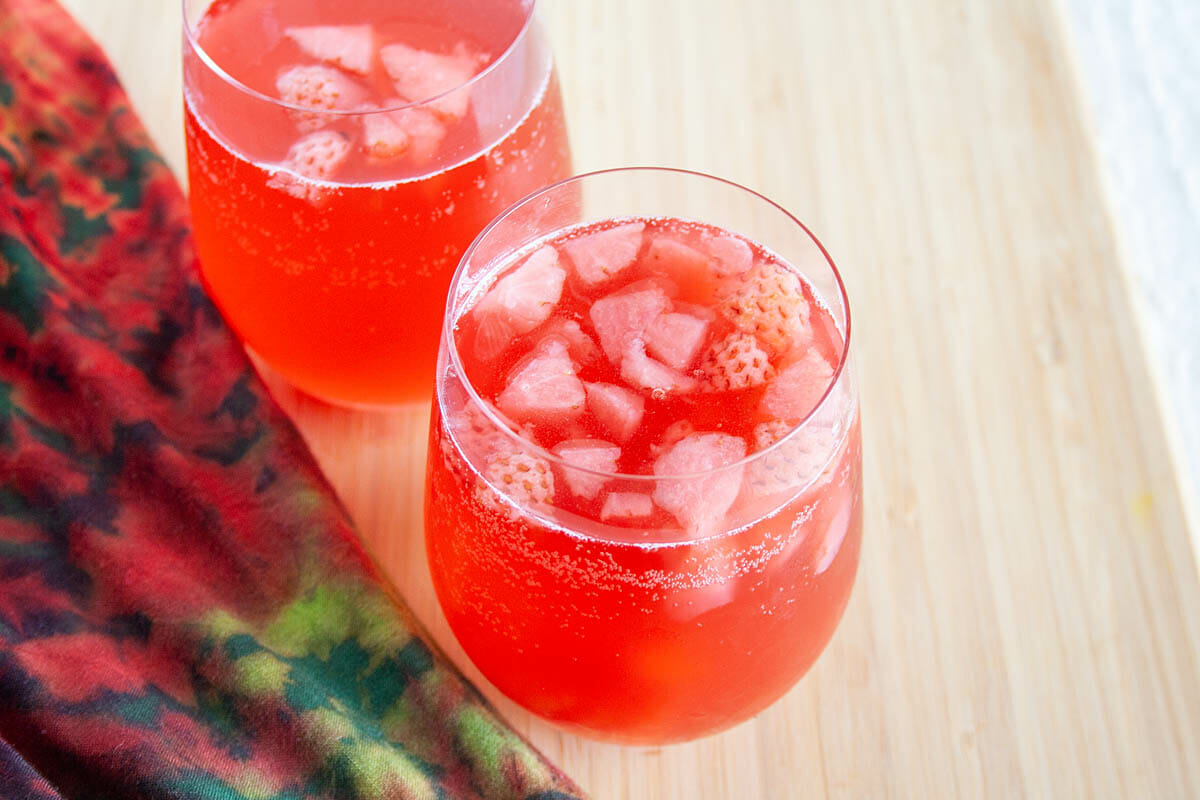 Strawberry Hibiscus Kombucha in two wine glasses.