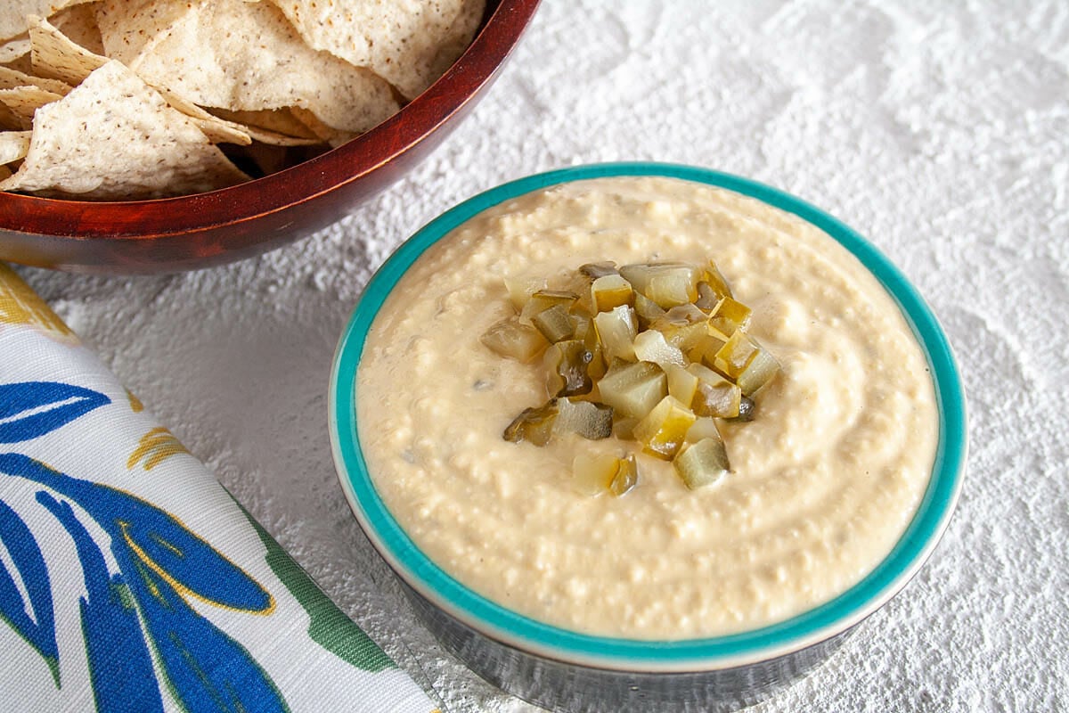 Dill Pickle Hummus with chopped dill pickles on top.