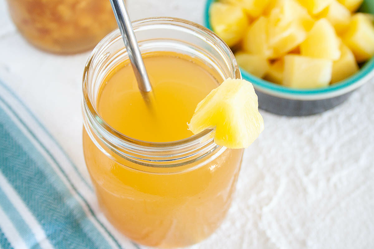 Pineapple Kombucha in a mason jar with straw.