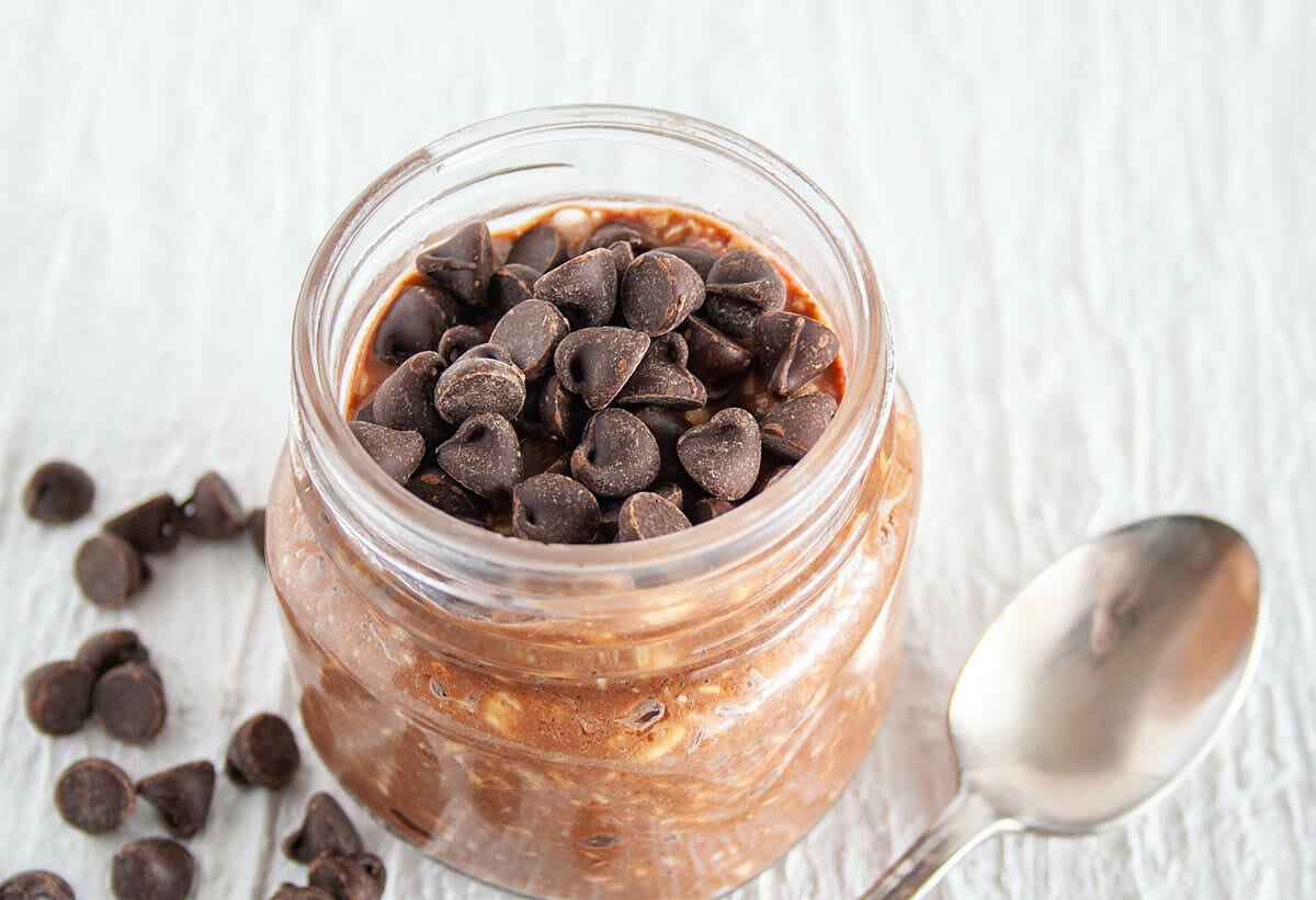 Chocolate Overnight Oats in mason jar with spoon.