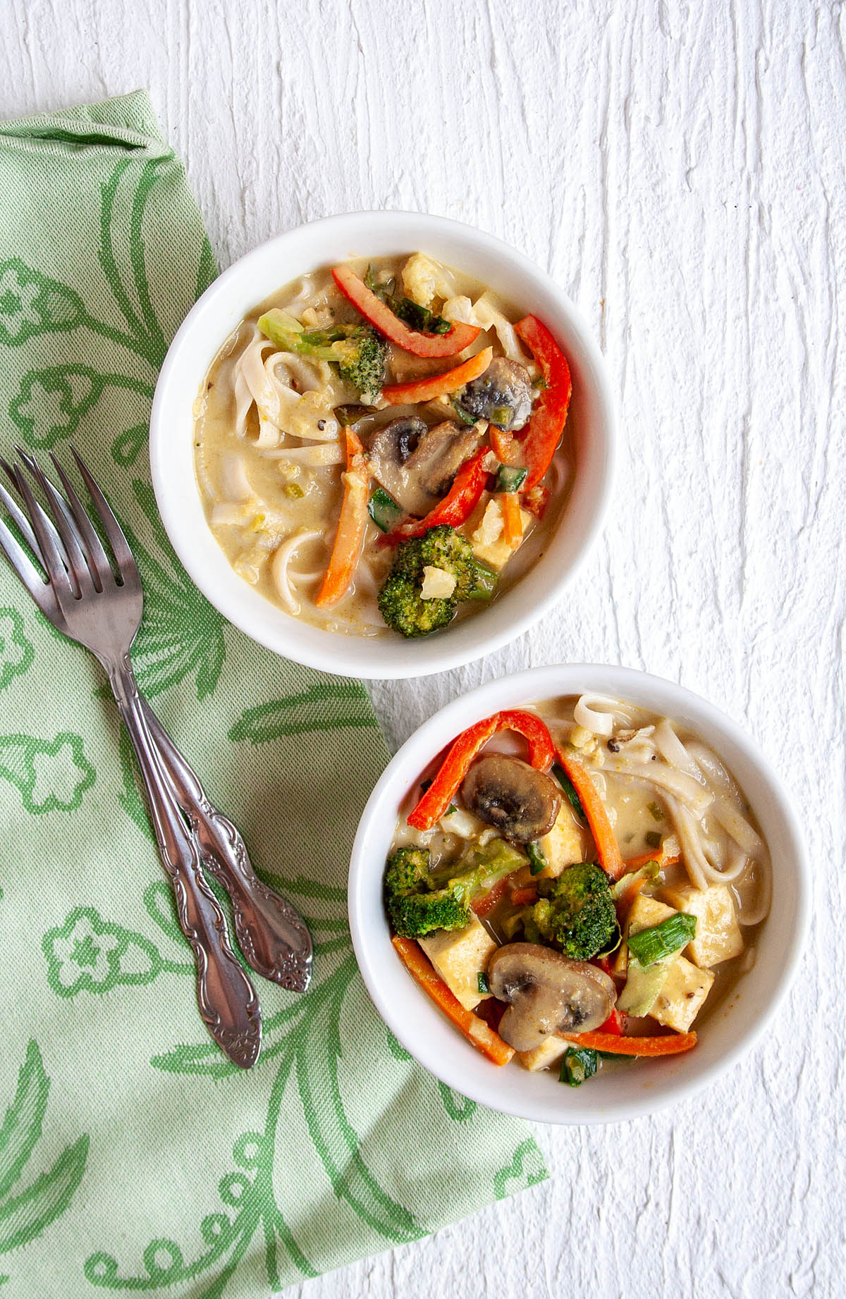 Green Curry with Tofu and Vegetables in two bowls bird's eye view.