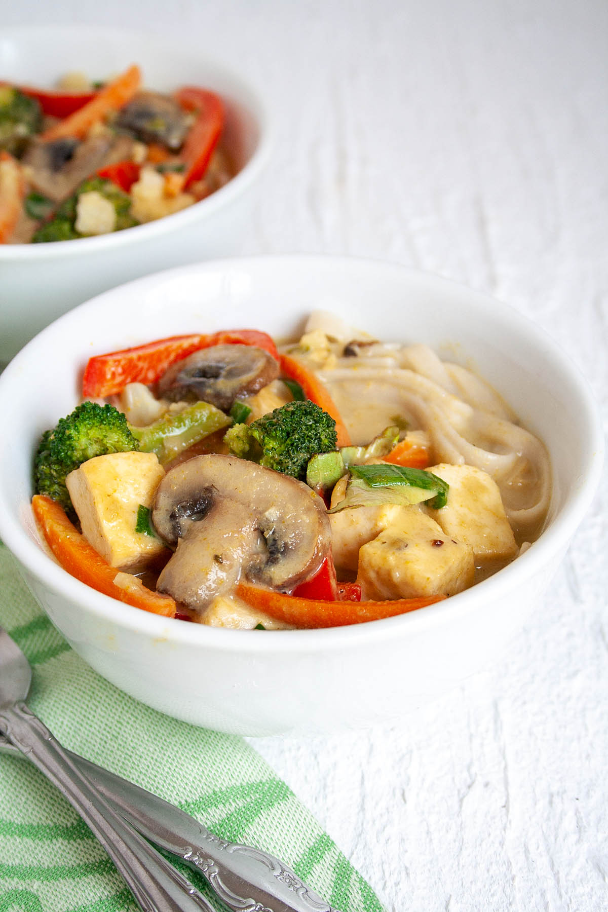 Green Curry with Tofu and Vegetables in a bowl with fork.