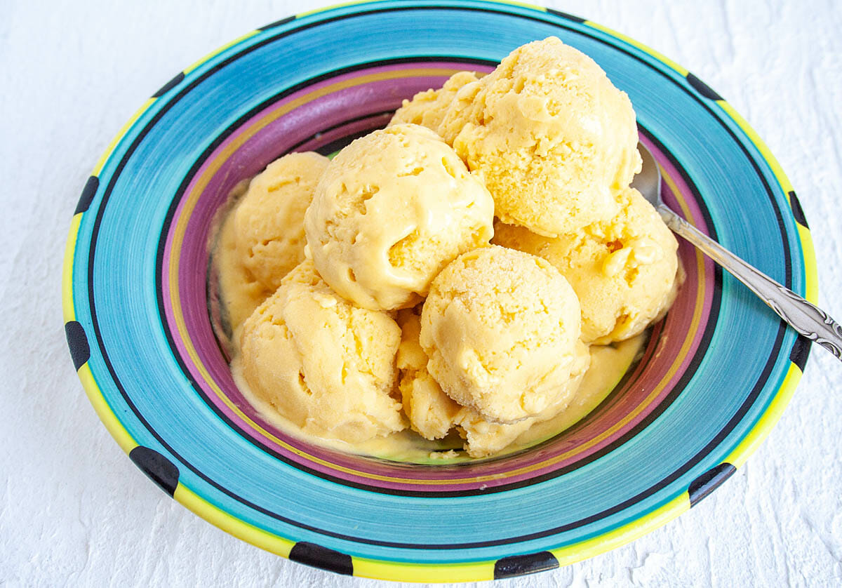 Mango Ice Cream in bowl with spoon.