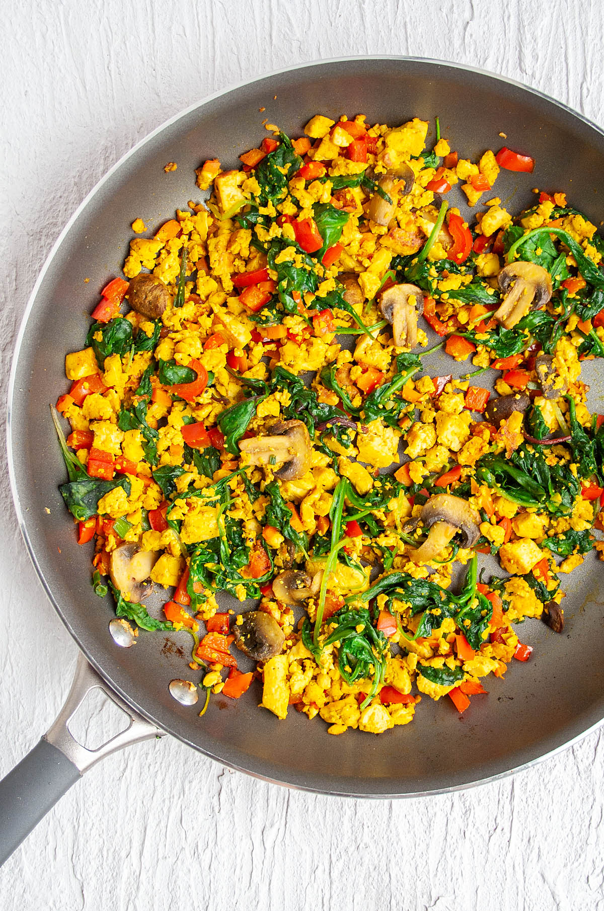 Tofu Scramble in a skillet after adding spinach and cooking.
