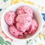 Cranberry Ice Cream in a bowl with a spoon.