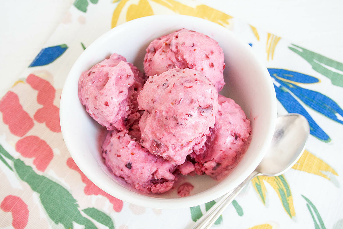 Cranberry Ice Cream in a bowl with a spoon.