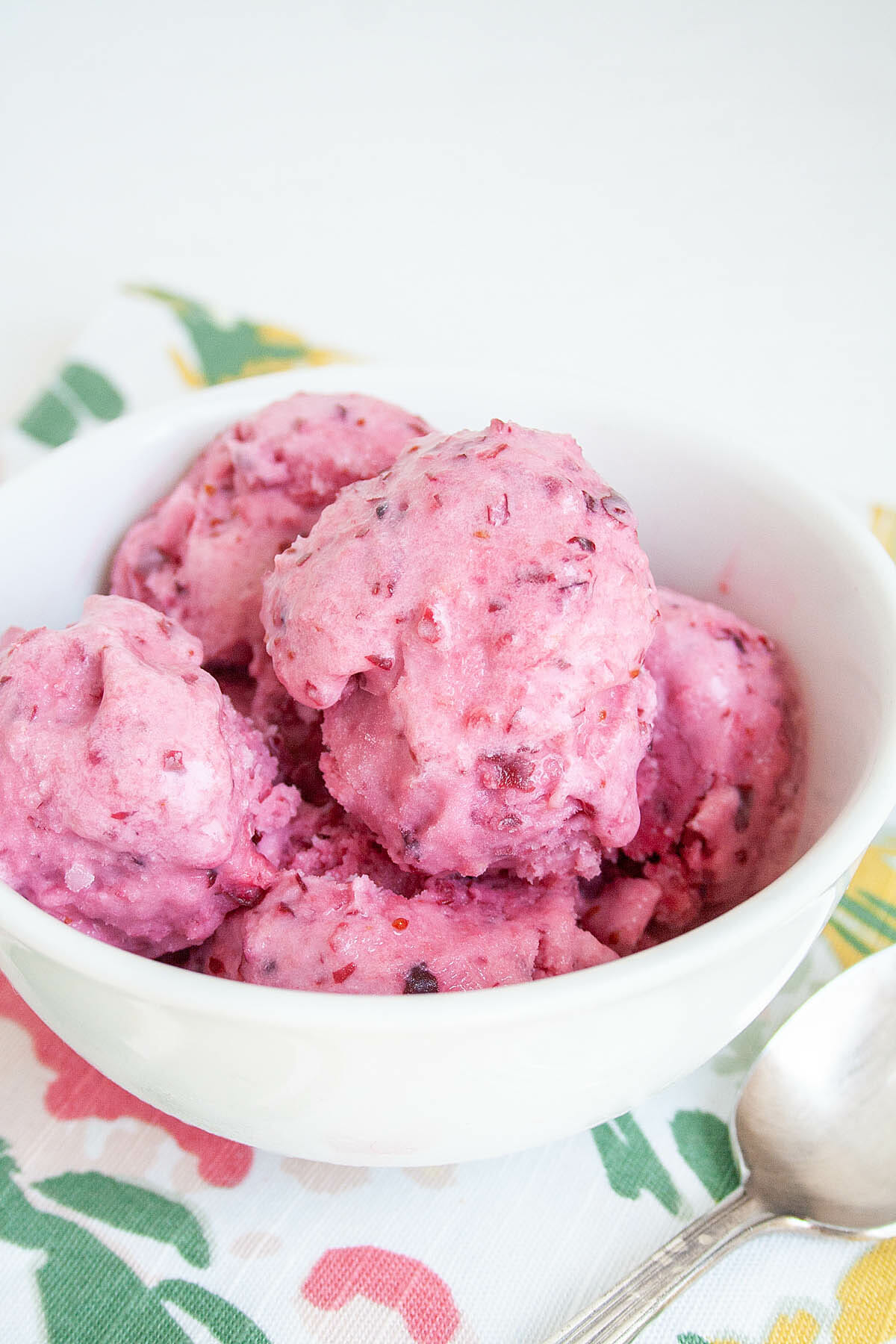 Cranberry Ice Cream in a bowl with a spoon.