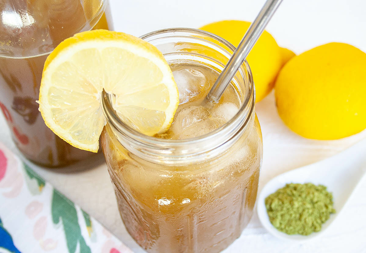 Matcha Lemon Kombucha with lemon slice and straw.