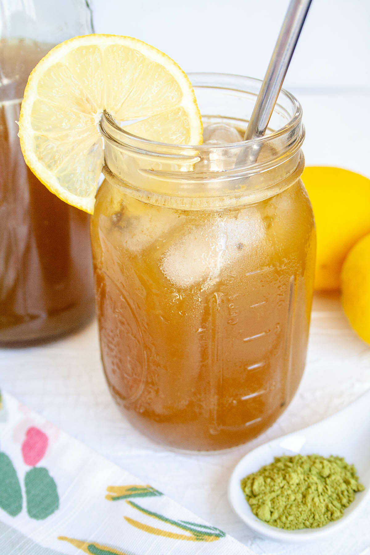 Matcha Lemon Kombucha in a mason jar with slice of lemon.