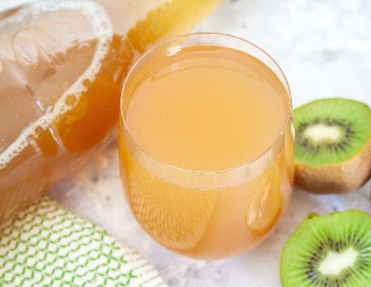 Kiwi Kombucha in glass with bottle.