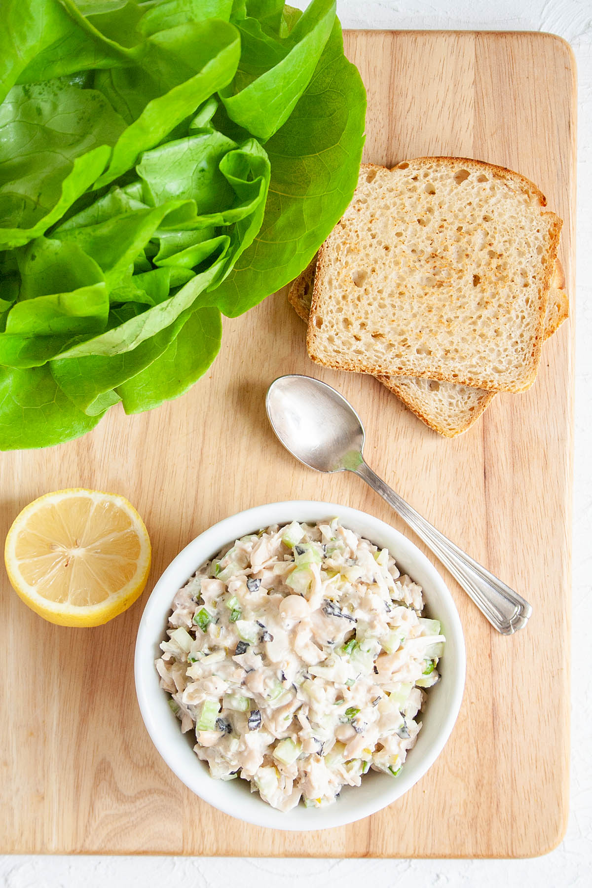 Vegan Tuna Salad in a bowl with toast, butter lettuce, and a lemon.