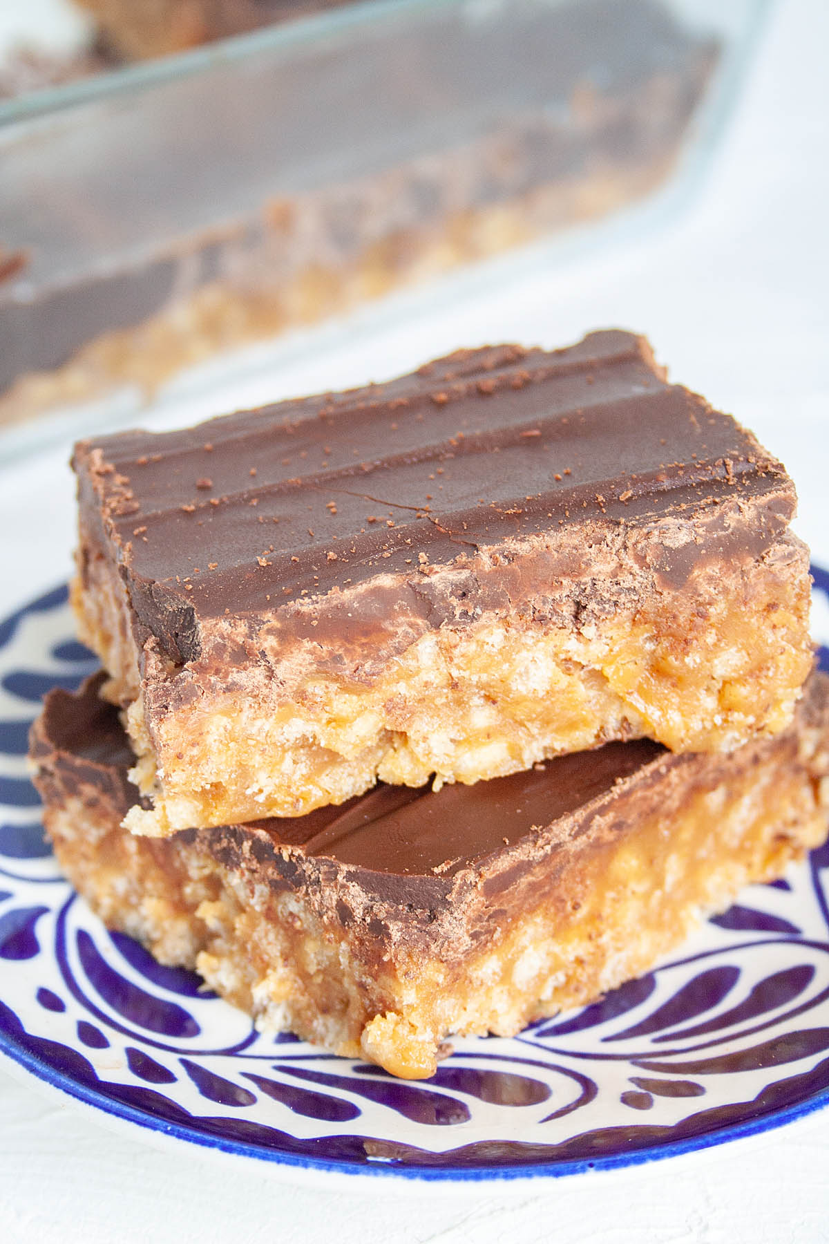 No-Bake Chocolate Peanut Butter Bars stacked on a plate close up.