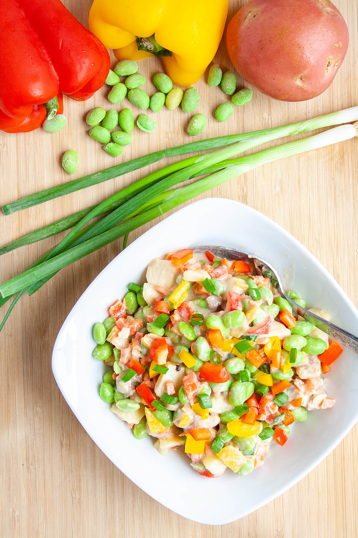 Edamame Potato Salad on cutting board with veggies.