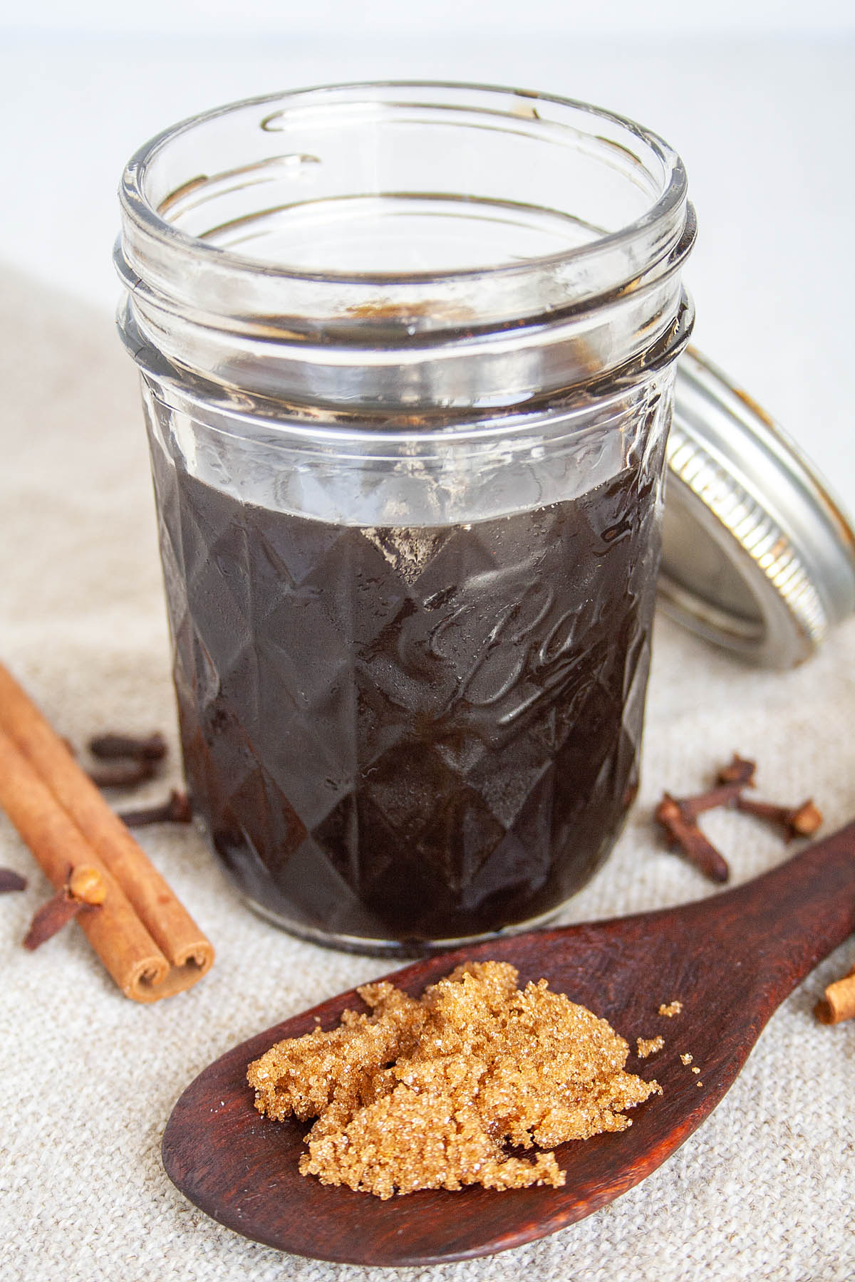 Chai Simple Syrup in mason jar with spoonful of brown sugar.