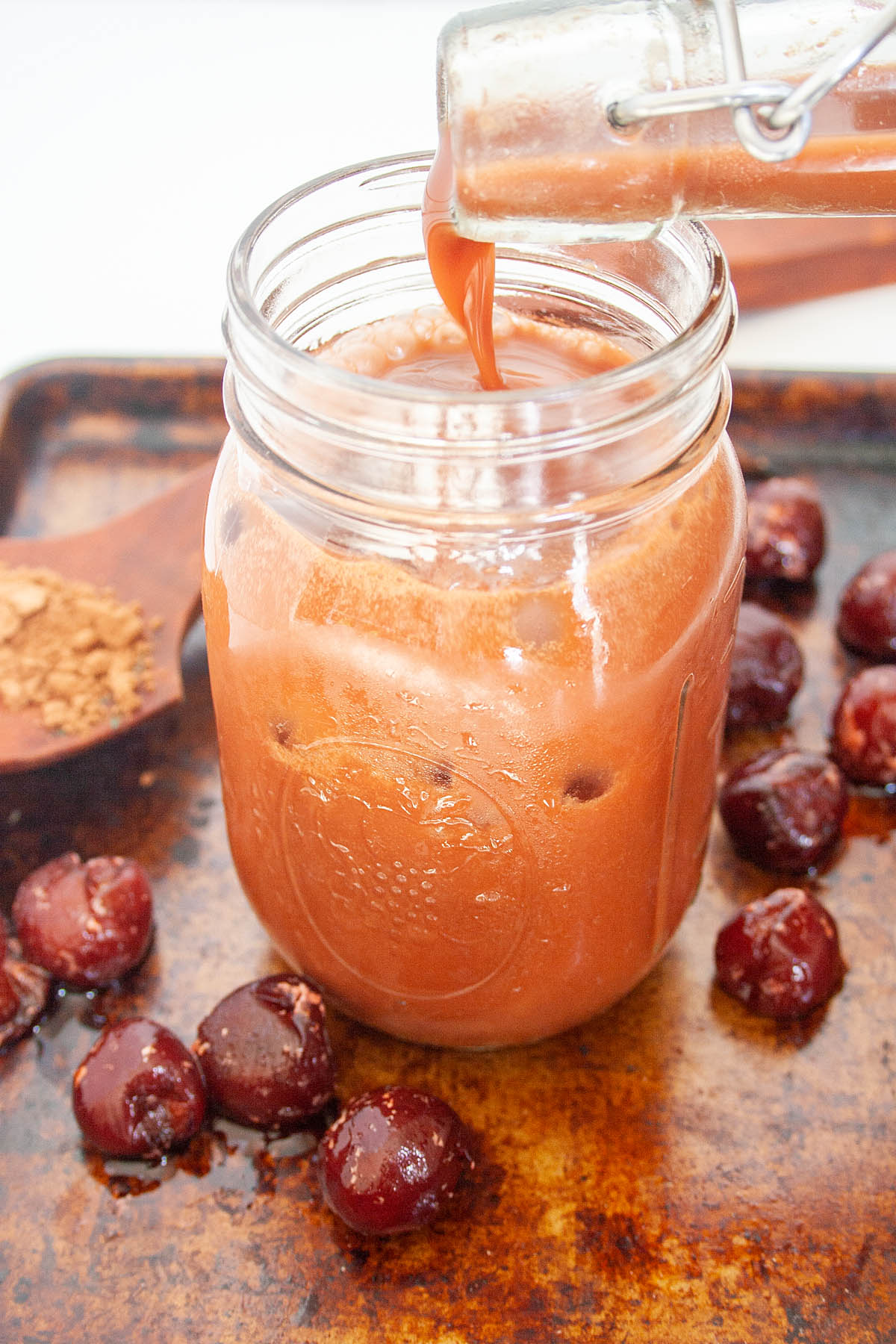 Chocolate Cherry Kombucha being poured into a mason jar.