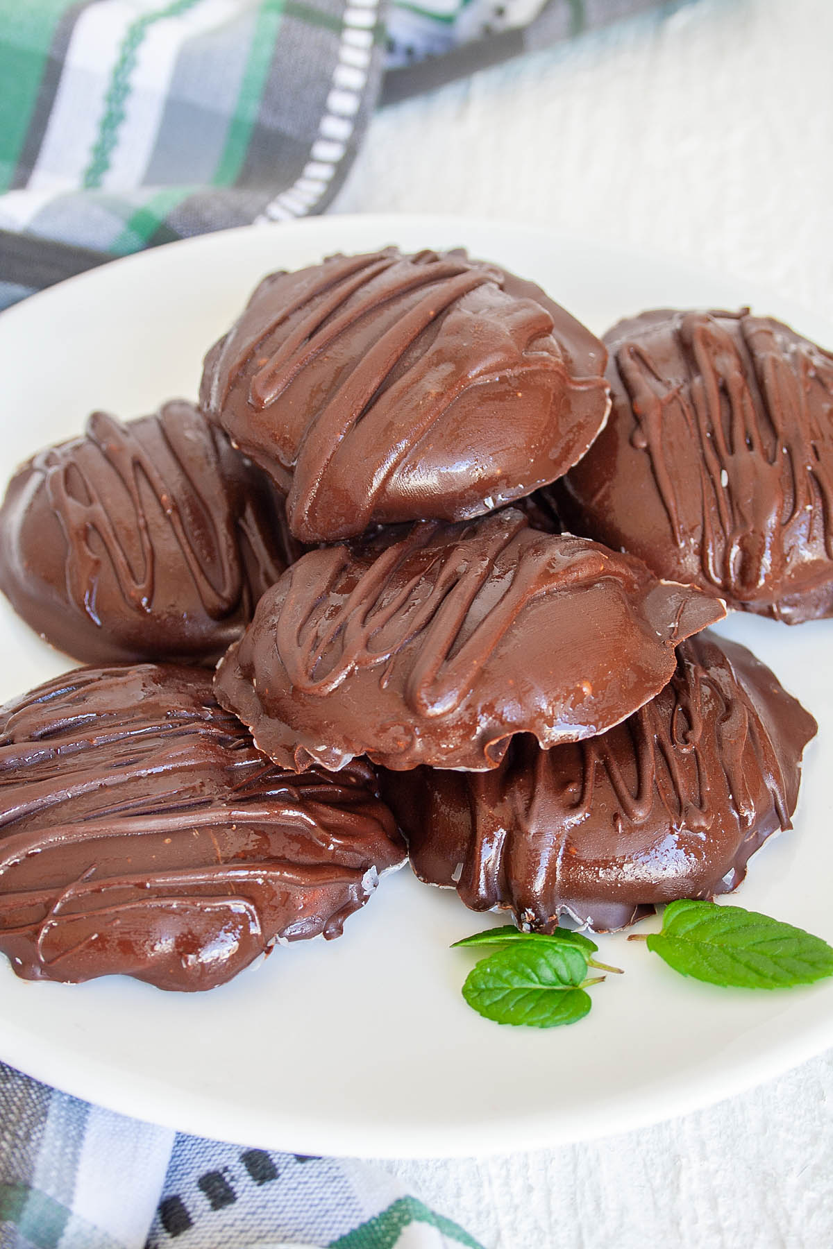 Vegan Peppermint Patties on plate with mint leaves.