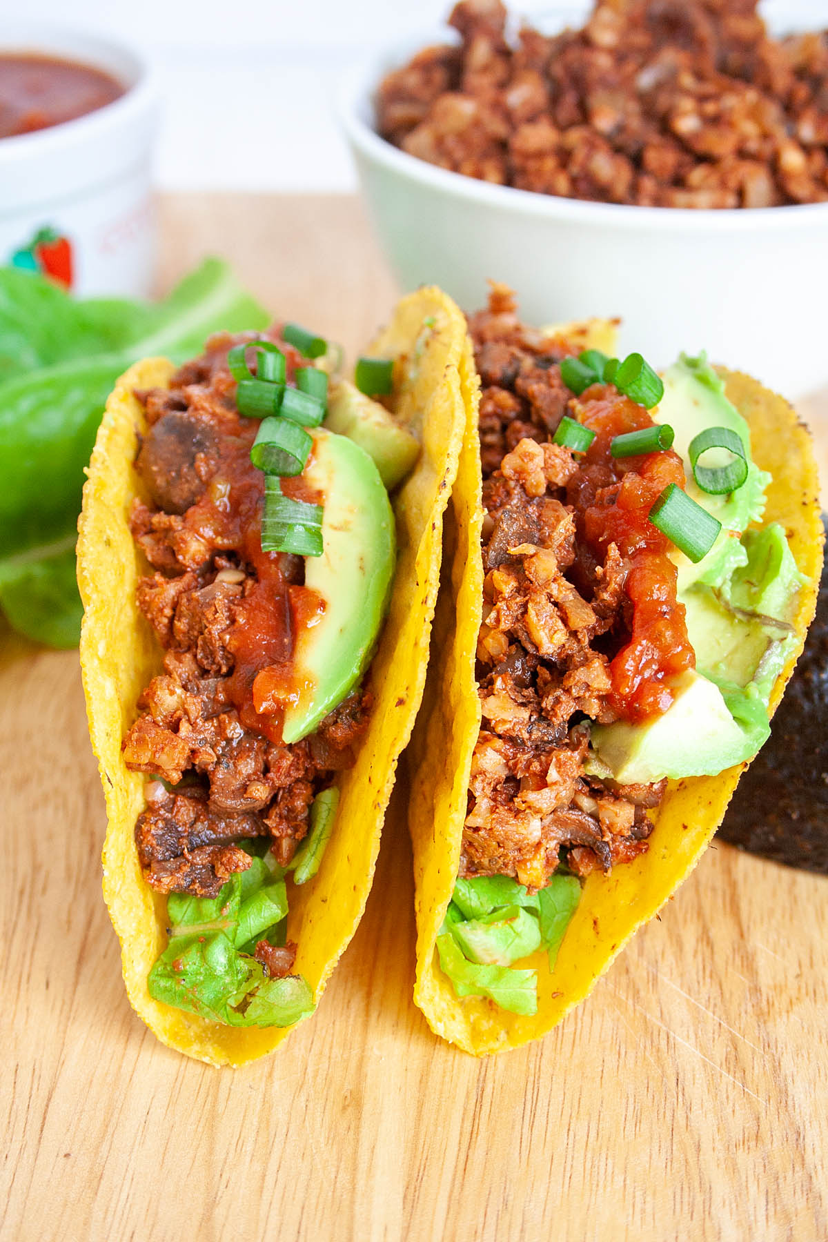 Walnut Taco Meat in tacos with avocado, lettuce, and green onions.