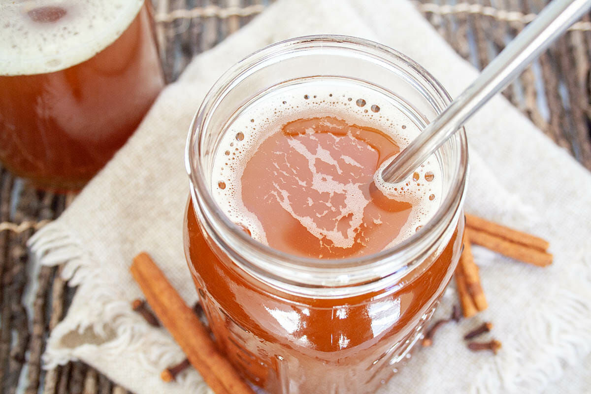 Chai Kombucha in mason jar with straw.