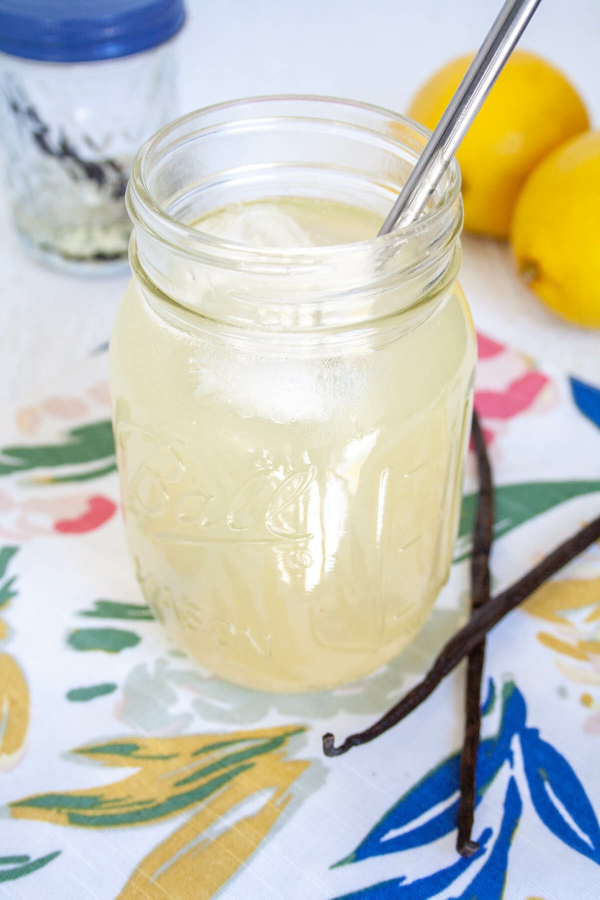 Vanilla Lemonade in a mason jar with vanilla beans, vanilla simple syrup, and lemons.