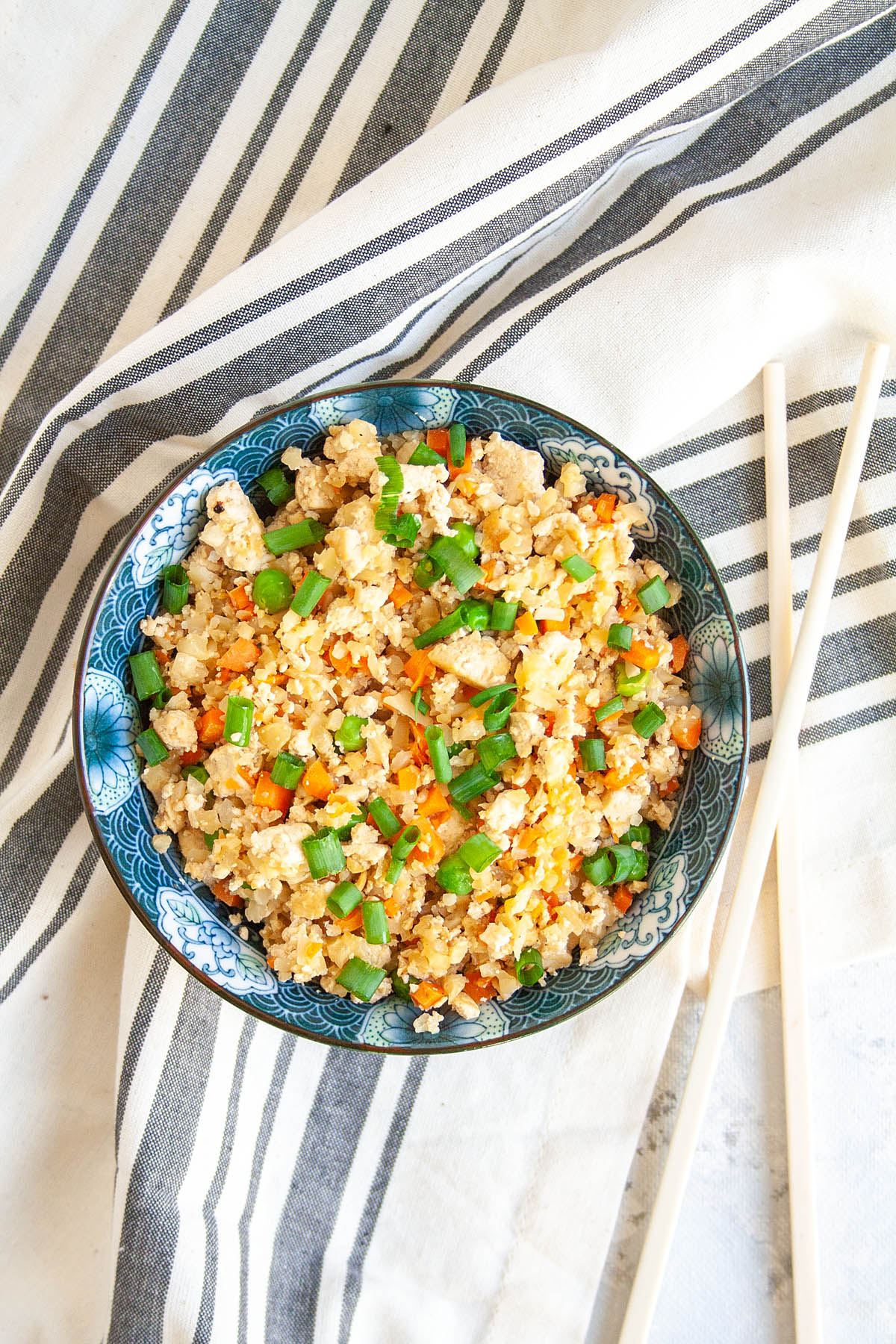 Vegan Cauliflower Fried Rice in a bowl with chopsticks.