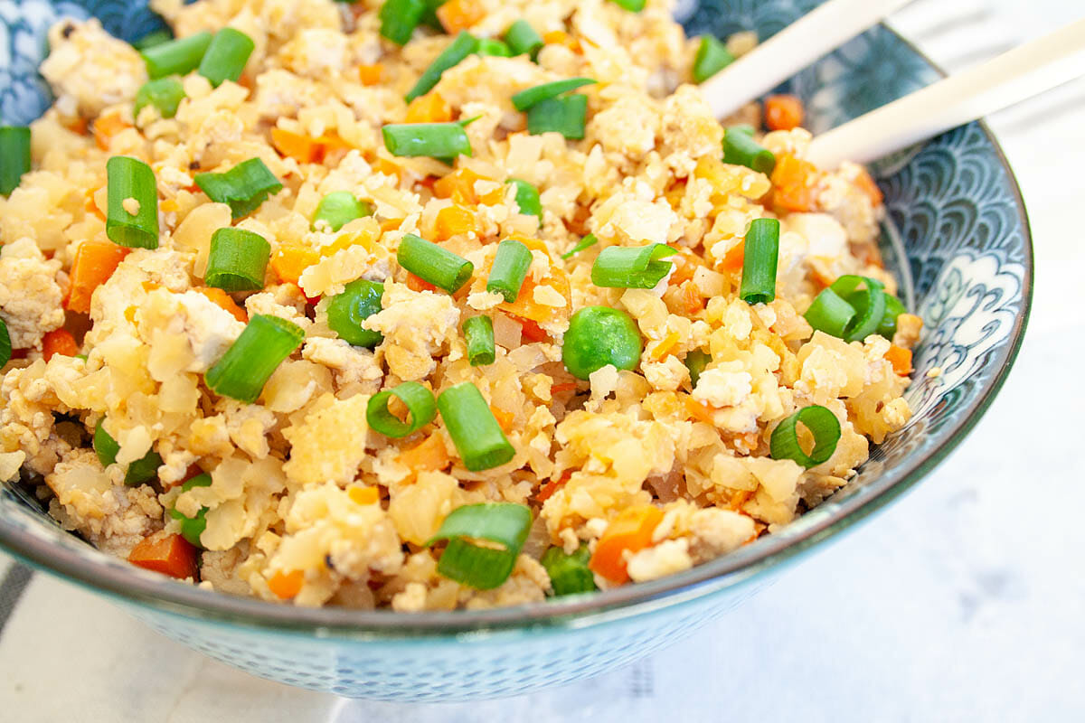 Vegan Cauliflower Fried Rice in a bowl with chopsticks.