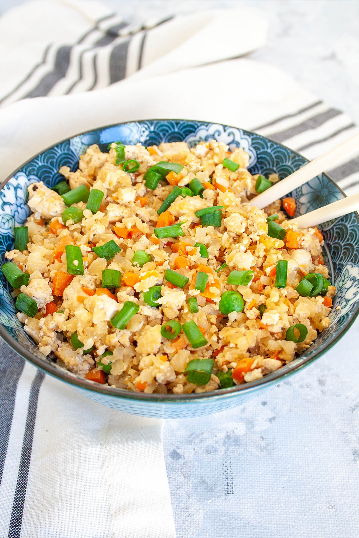 Vegan Cauliflower Fried Rice in a bowl with chopsticks.