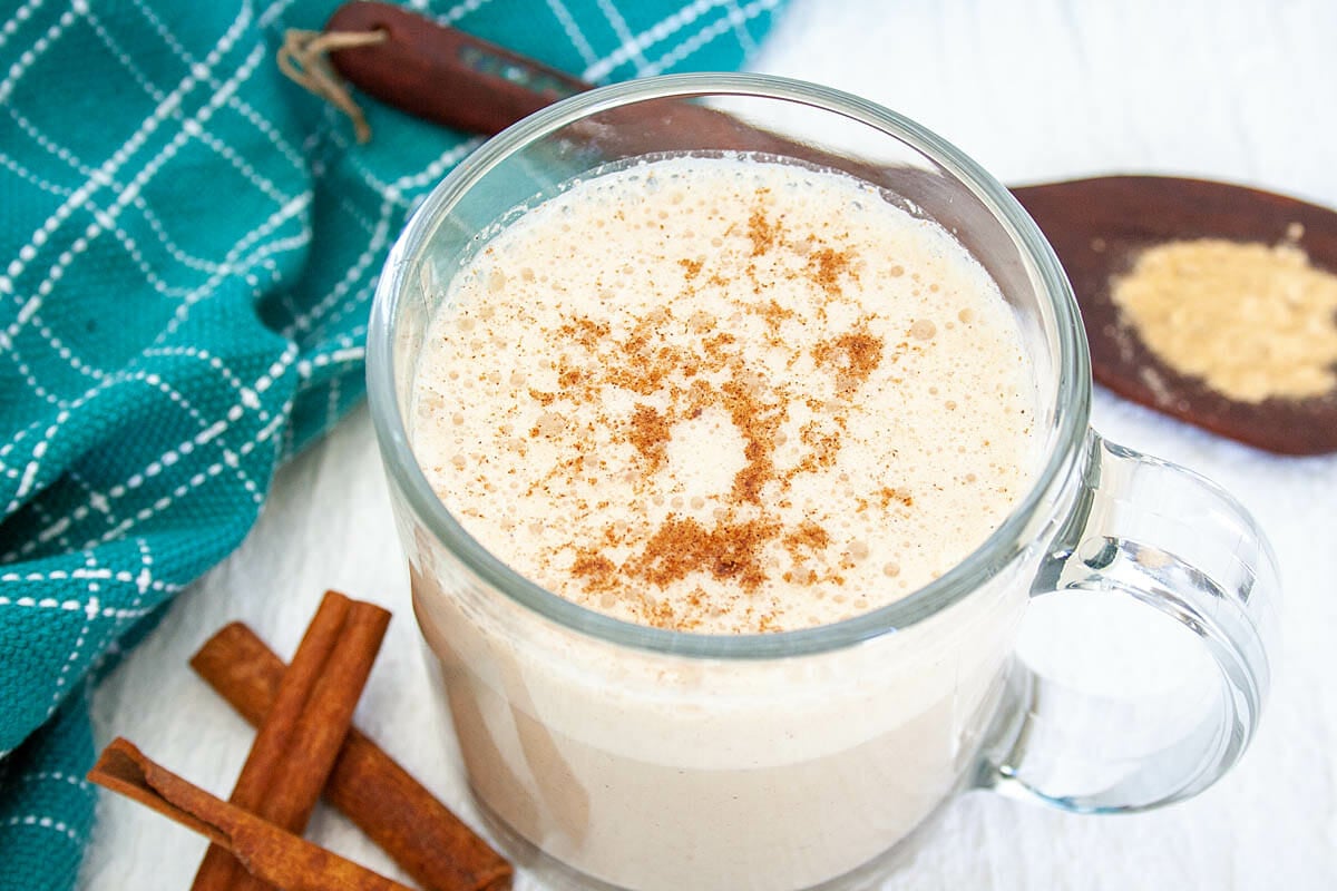 Maca Latte with spoonful of maca and cinnamon sticks.