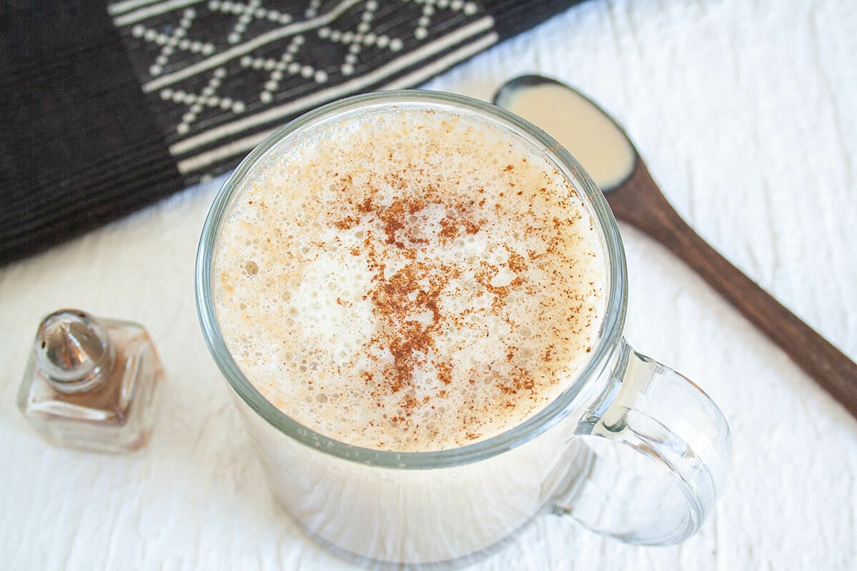 Maple Tahini Latte in a mug with cinnamon and spoonful or tahini.