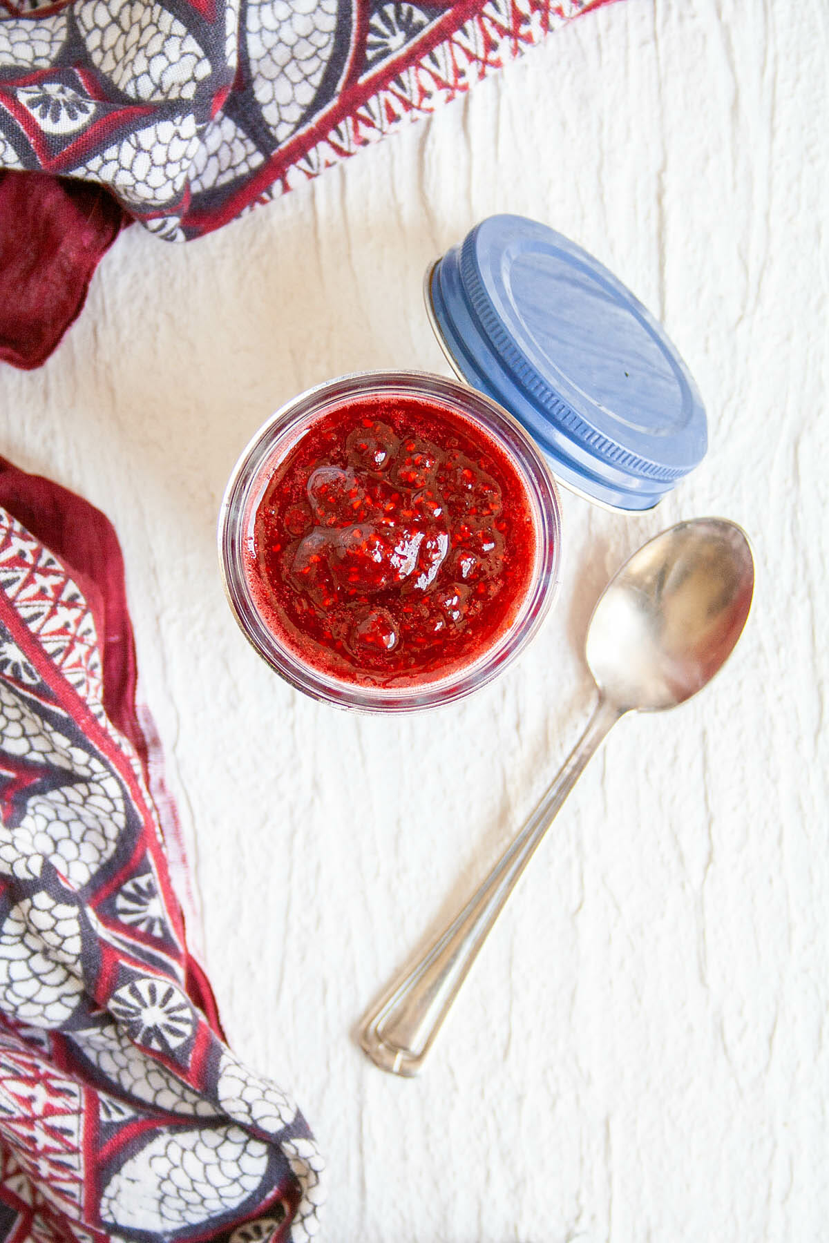 Raspberry Compote in mason jar with spoon.