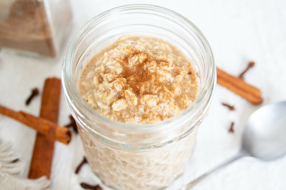 Chai Overnight Oats in mason jar with spoon and spices.