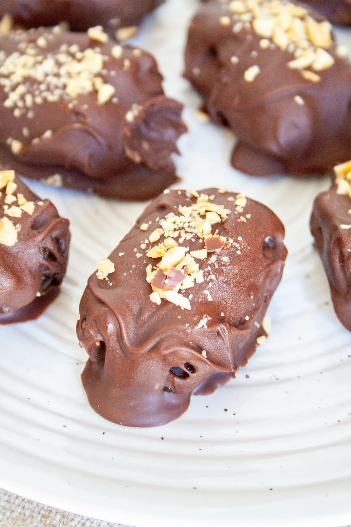 Chocolate Covered Peanut Butter Stuffed Dates on a plate close up.