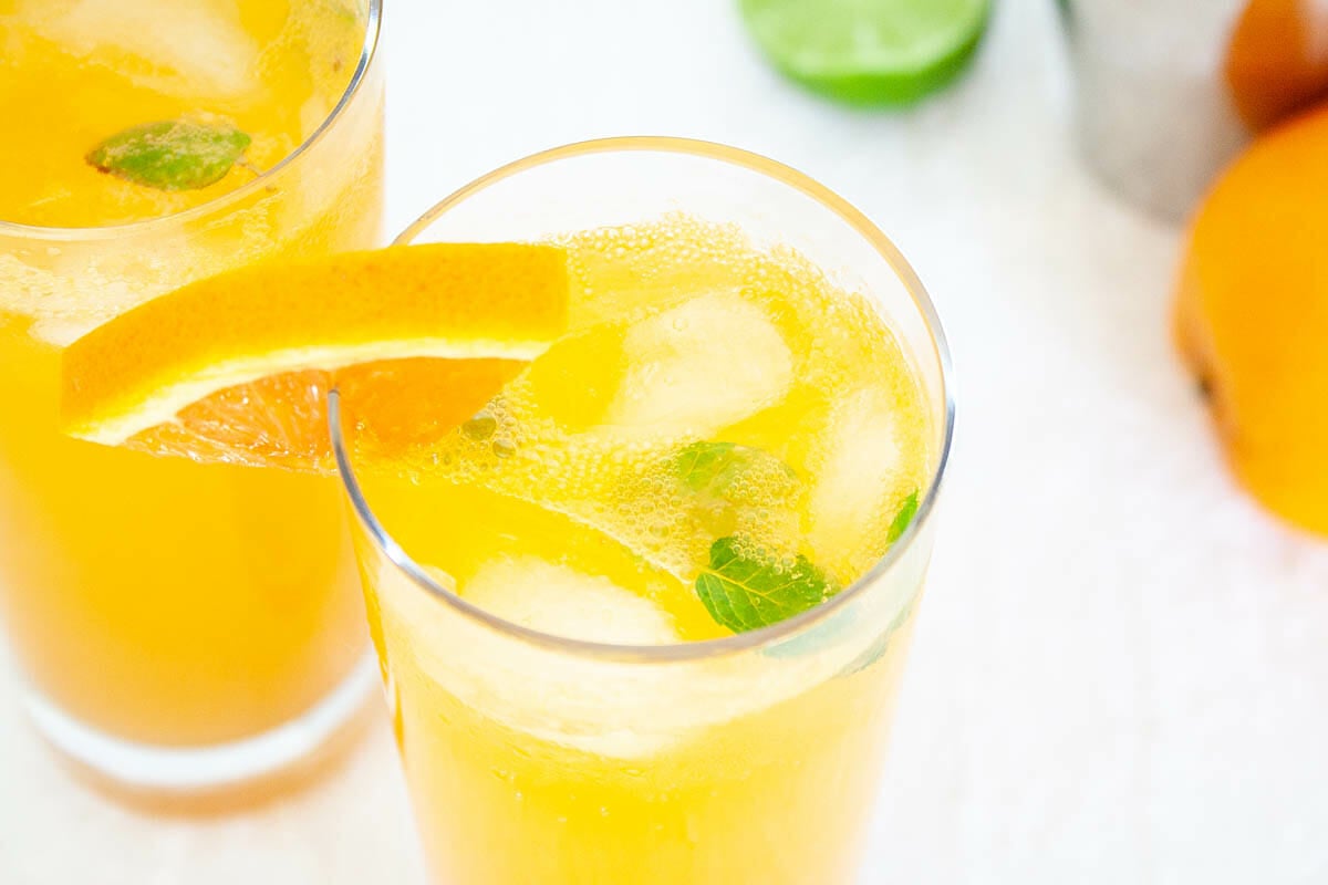 Orange Mocktail Mojito in two glasses.