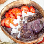 Superfood Smoothie Bowl in a coconut bowl with spoon.