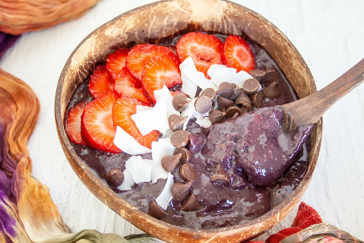 Superfood Smoothie Bowl in a coconut bowl with spoon.