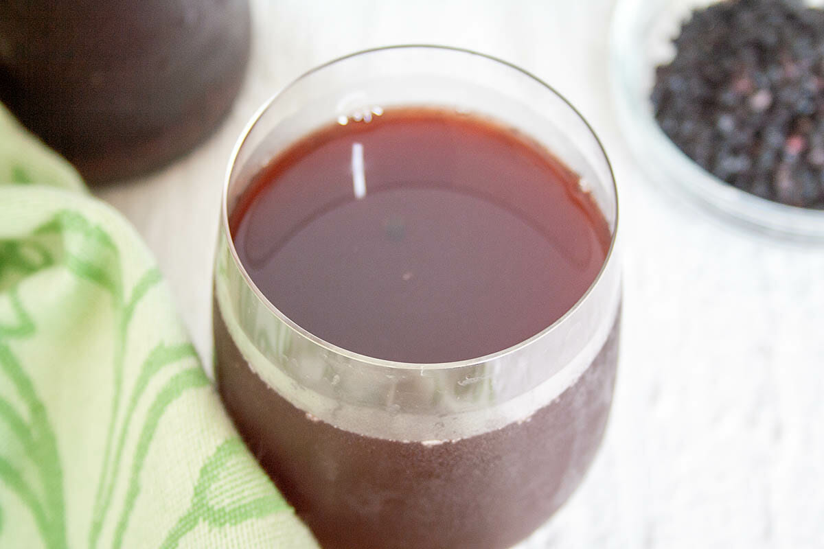 Elderberry Kombucha in glass close up.