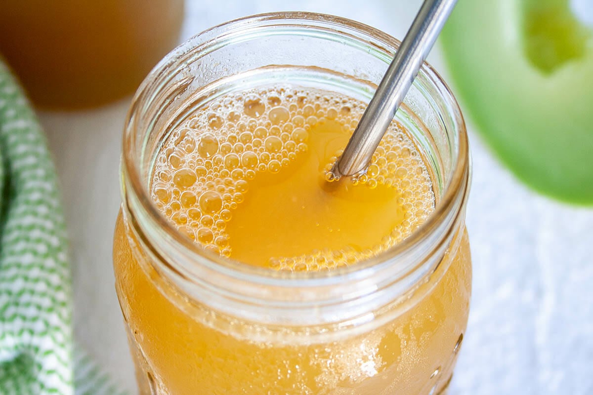 Honeydew Kombucha in a mason jar with straw.